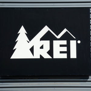 REI sign hanging on a metal wall