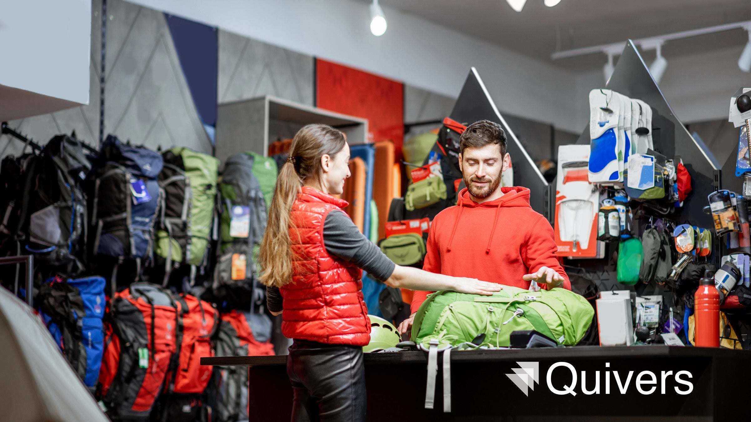 Young woman buying sports goods standing with salesman at a counter