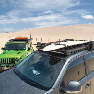 Two jeeps on the beach with roof racks