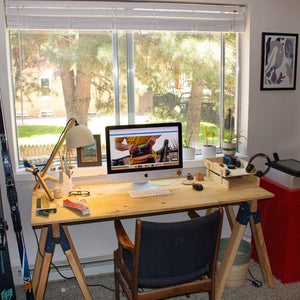 Home office for remote work with wooden desk an computer set in front of a window