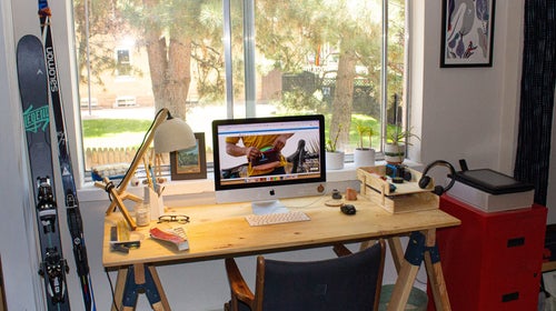 Home office for remote work with wooden desk an computer set in front of a window
