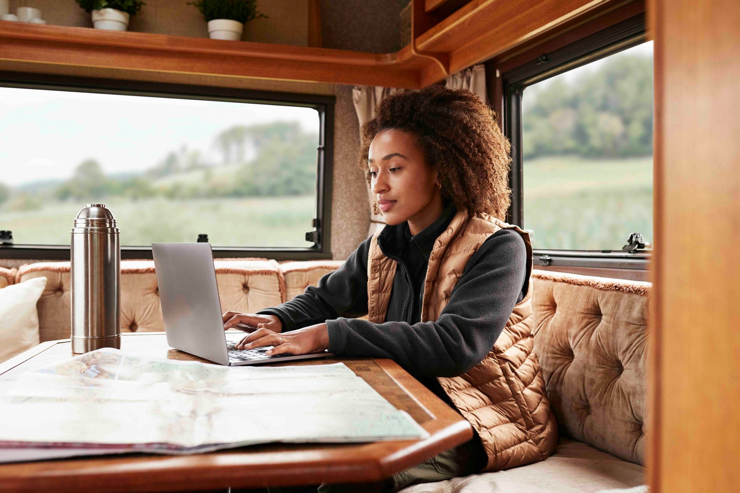 Woman using laptop in camper van on vacation