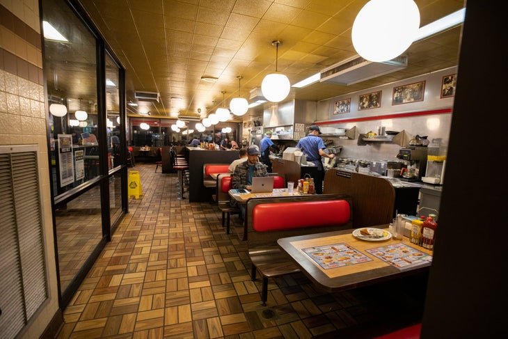 Jesse Albanese works on his laptop in a diner / photos for sales rep story in The Voice