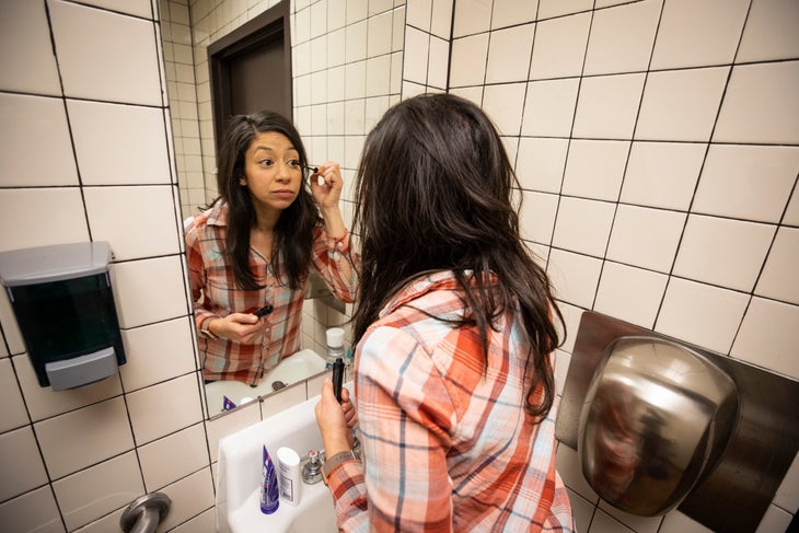 Louisa Albanese puts on mascara in generic bathroom / photo for sales rep story