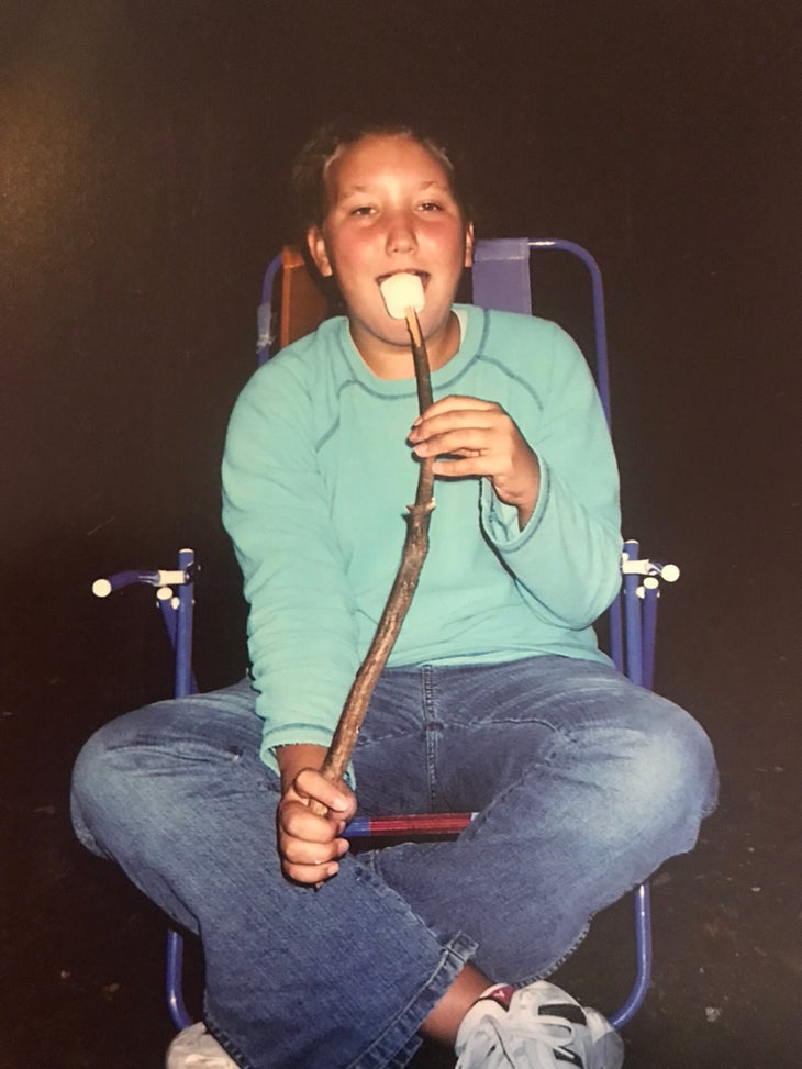 Betsy Bertram as a child eating a marshmallow while camping