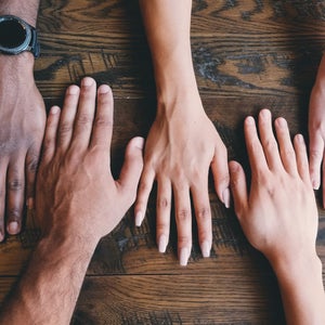 Five hands on a table
