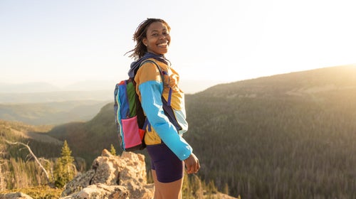 BIPOC woman standing on mountain top