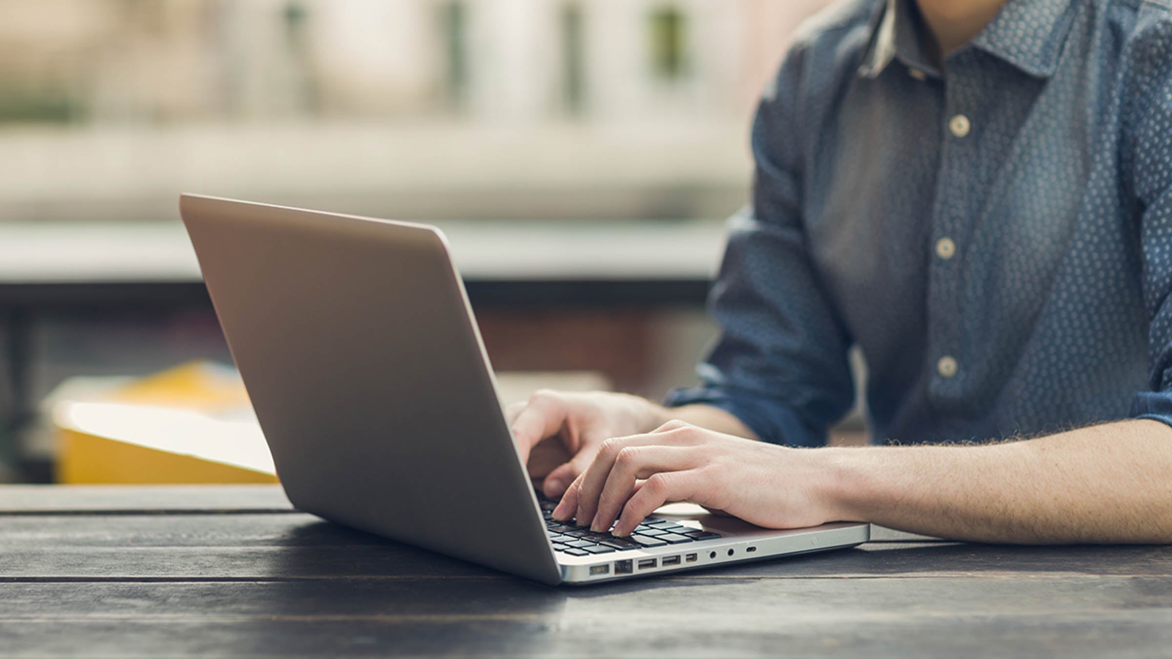 Close up of hands typing on a laptop
