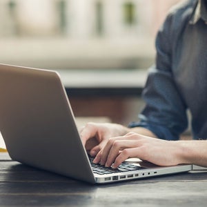 Close up of hands typing on a laptop