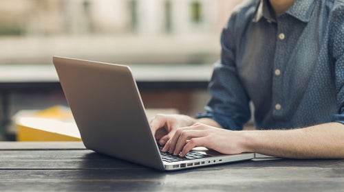 Close up of hands typing on a laptop