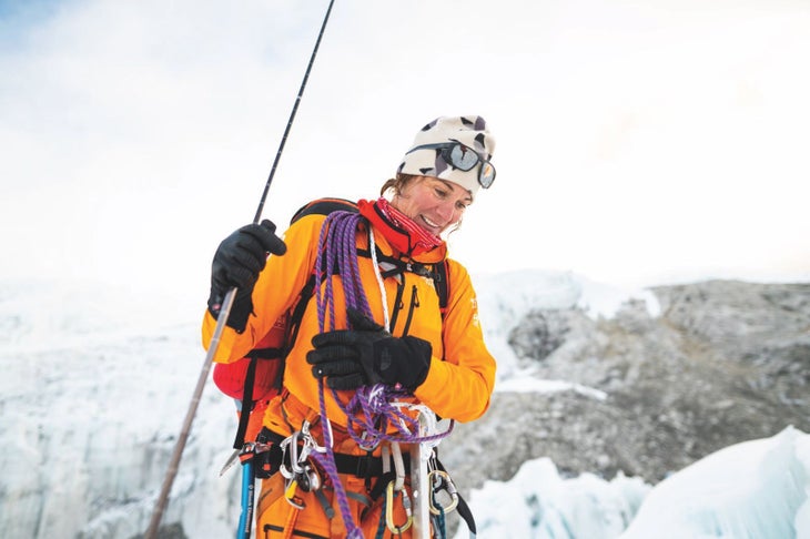 Hillaree O'Neill wearing an orange jacket with lots of climbing gear on The North Face FutureLight expedition