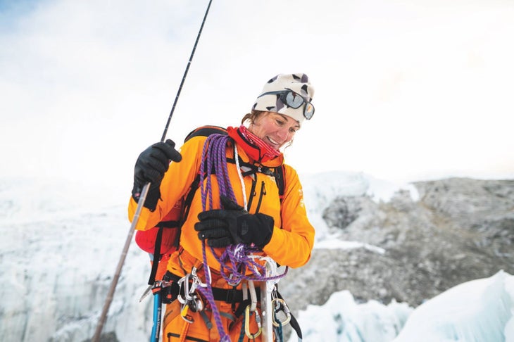 FL_Expedition Hillaree O'Neill wearing an orange jacket with lots of climbing gear on The North Face FutureLight expedition