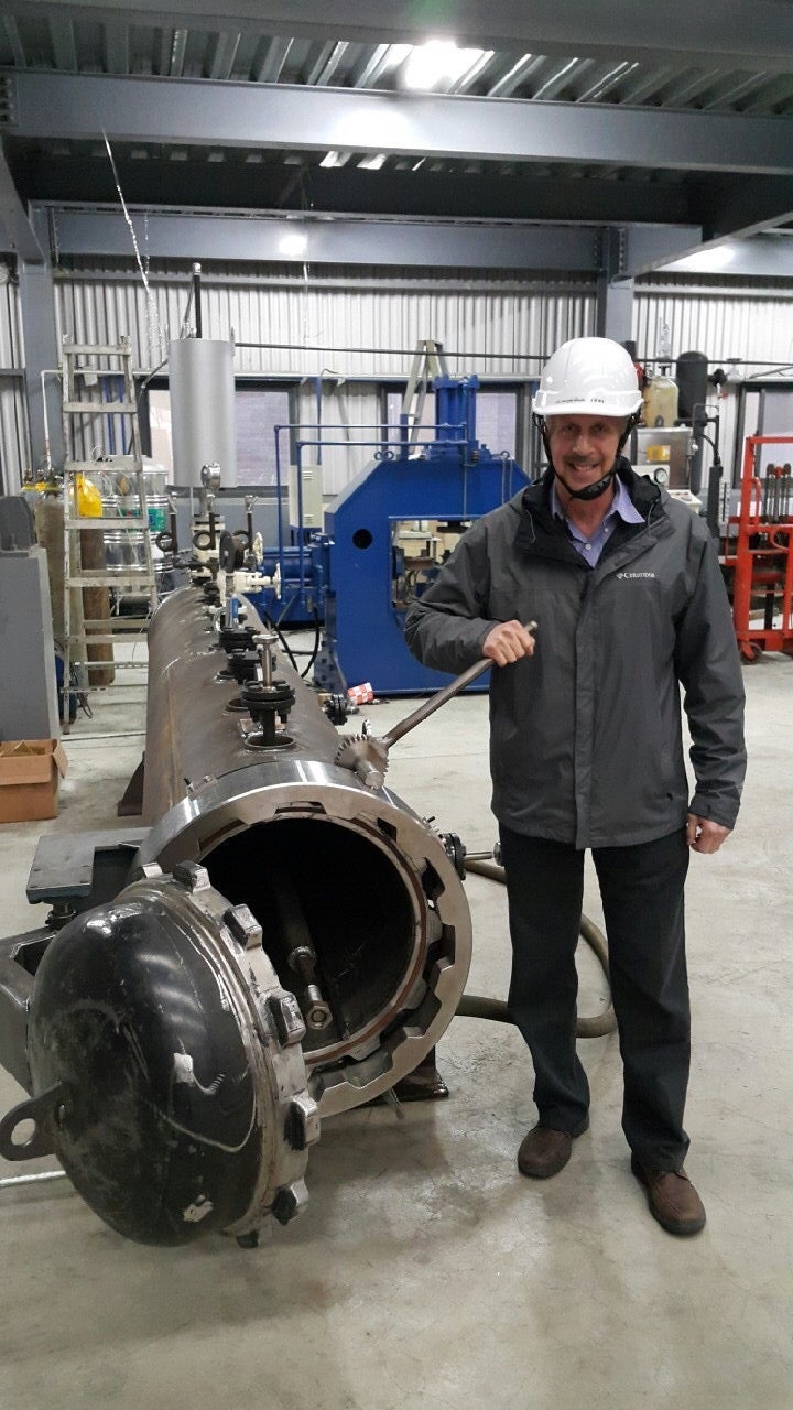 Green Theme International | Dr. Gary Selwyn standing in hardhat and black jacket with Mega Pod