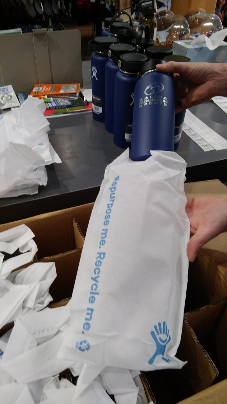 Hydro Flask blue bottle being removed from reusable bag, a good example of sustainable packaging