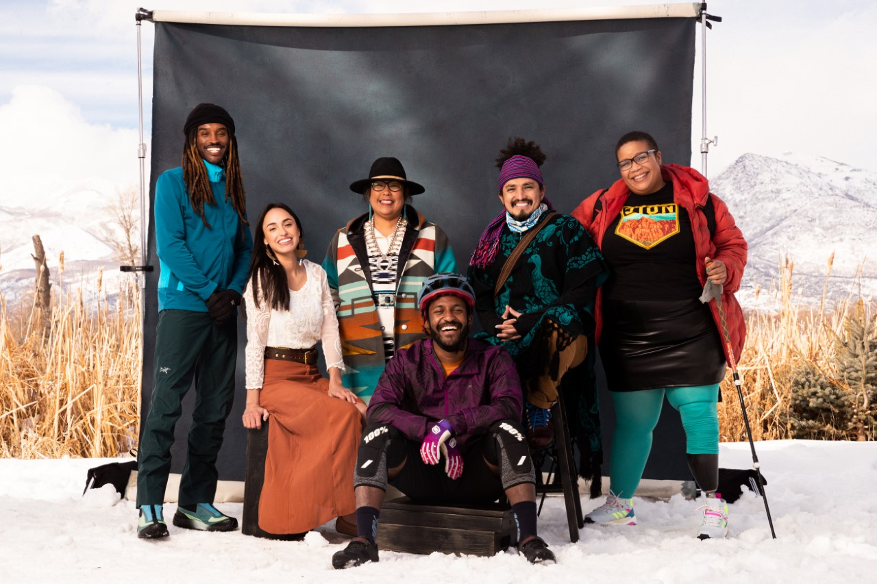 Six Black, Indiegenous, and people of color pose in front of a black backdrop