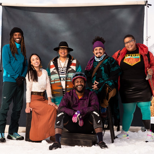 Six Black, Indiegenous, and people of color pose in front of a black backdrop
