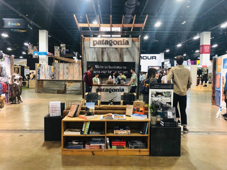 Patagonia booth at Outdoor Retailer with shelves of books, corrugated metal