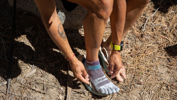 Trail runner putting on Injinji toe socks