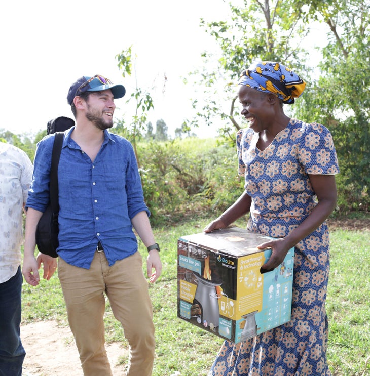 Jonathan Cedar, founder of Biolite delivers a stove to a smiling African woman