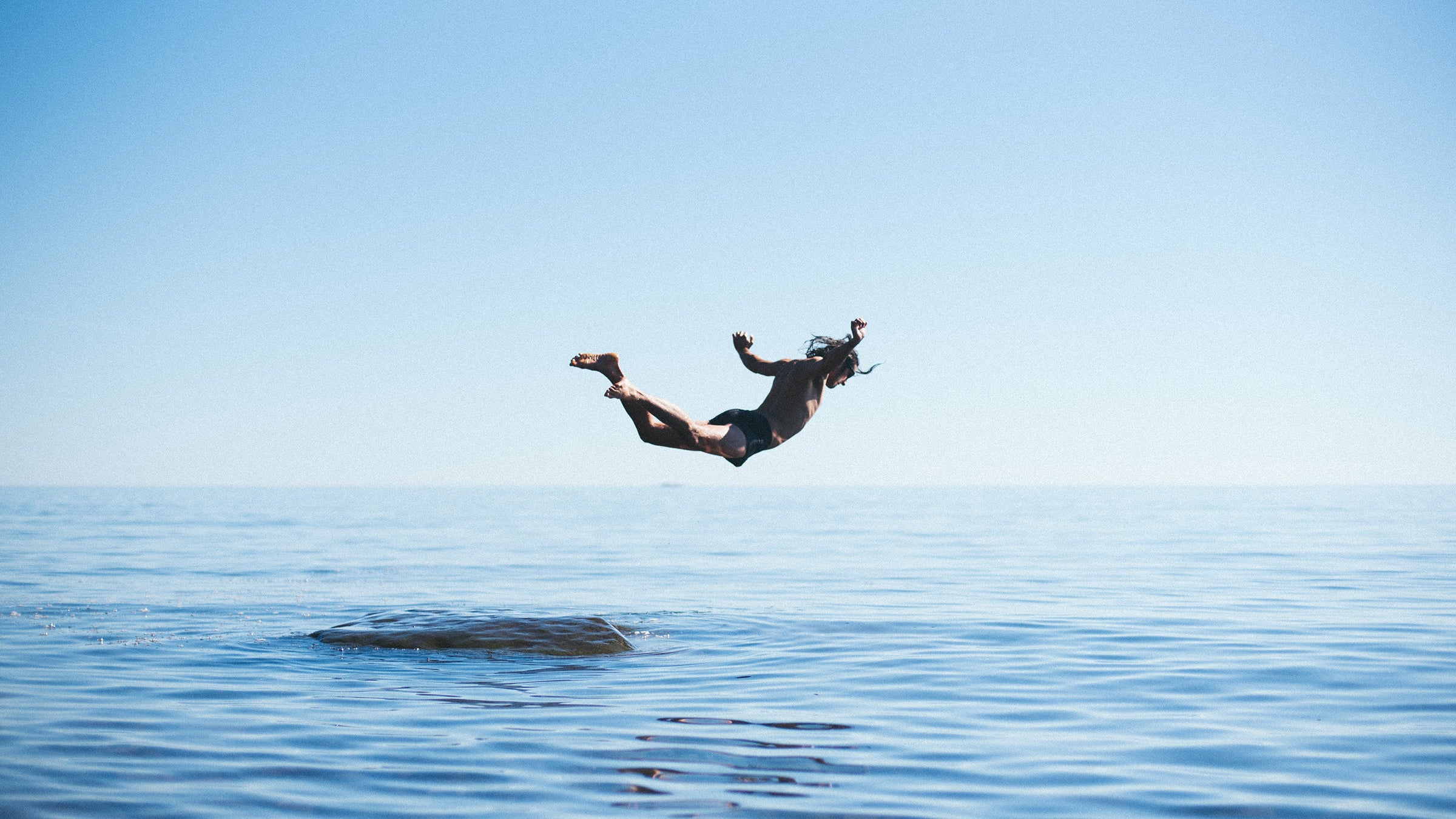 A man dives from a rock at Cutface Creek Waydeside in Minnesota after driving along the north shore of Lake Superior.