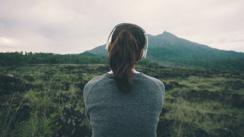 Woman in headphones listening music in nature