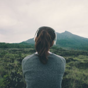 Woman in headphones listening music in nature