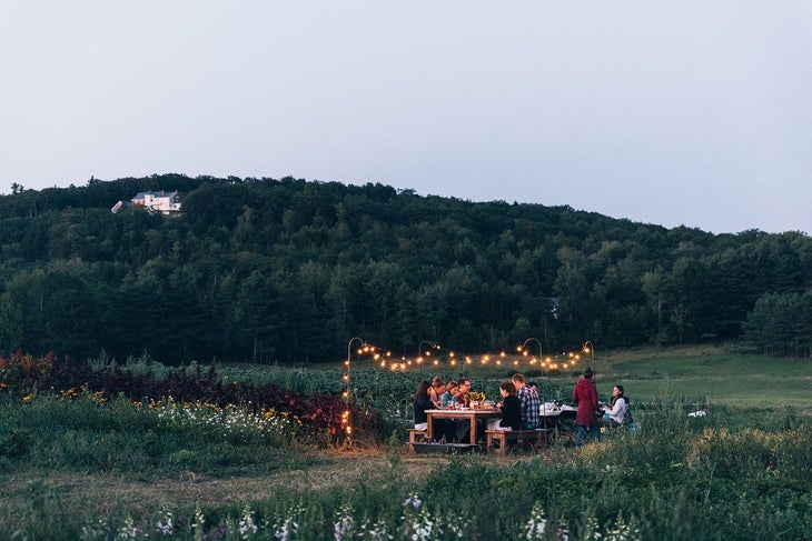 maine dinner party Friends have a dinner party in Maine under string lights