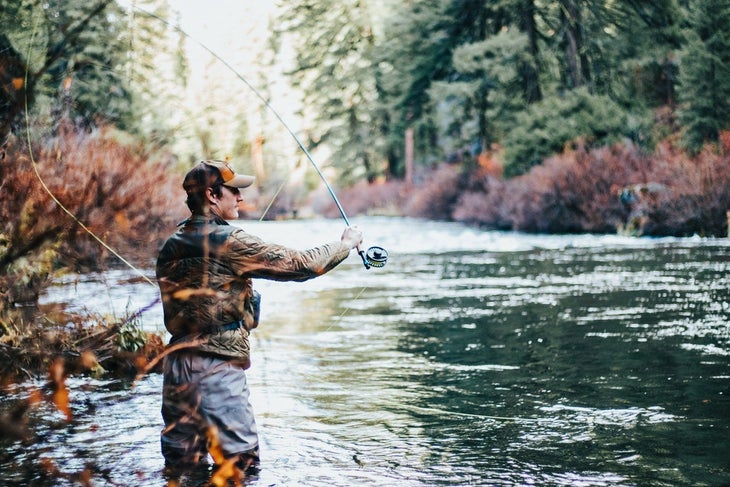 man fly fishing A man fly fishing over a river