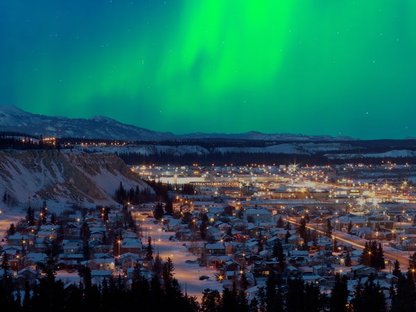 Strong northern lights (Aurora borealis) substorm on night sky over downtown Whitehorse, capital of the Yukon Territory, Canada, in winter.