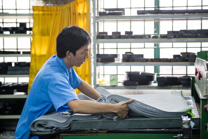 A worker in a blue shirt moving fabric in Osprey's Vietnam backpack factory