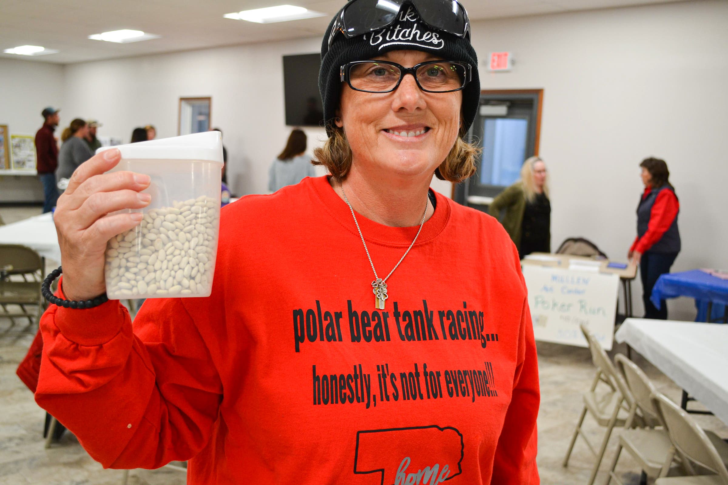 Party at the community center! Veteran racer Lori McMullen holds up beans used to cast votes in the soup cook-off.