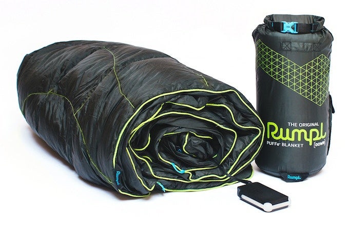 Power Practical, Rumpl, and Ravean collab | black quilted blanket with lime green trim rolled next to stuffsack and battery pack