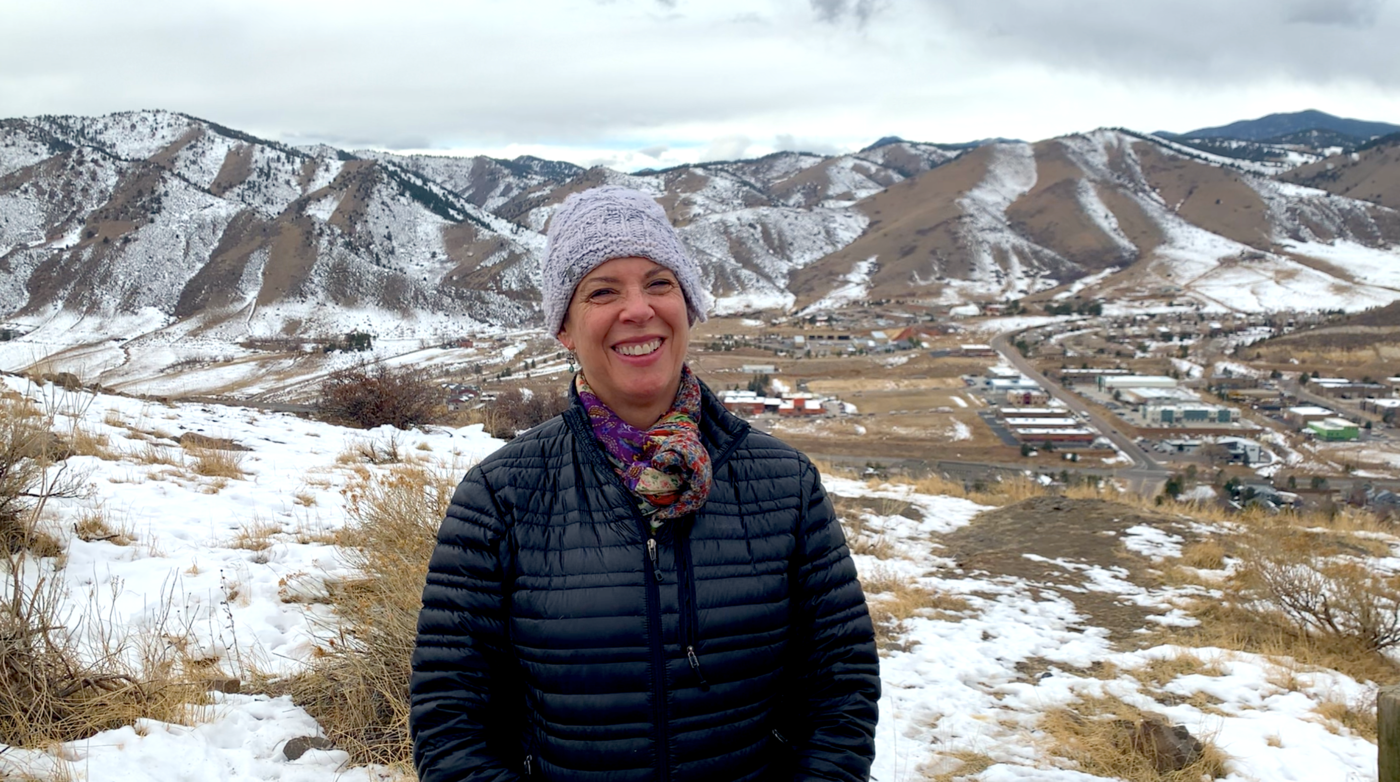 Woman in gray hat standing in a snowy landscape