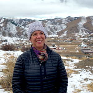 Woman in gray hat standing in a snowy landscape