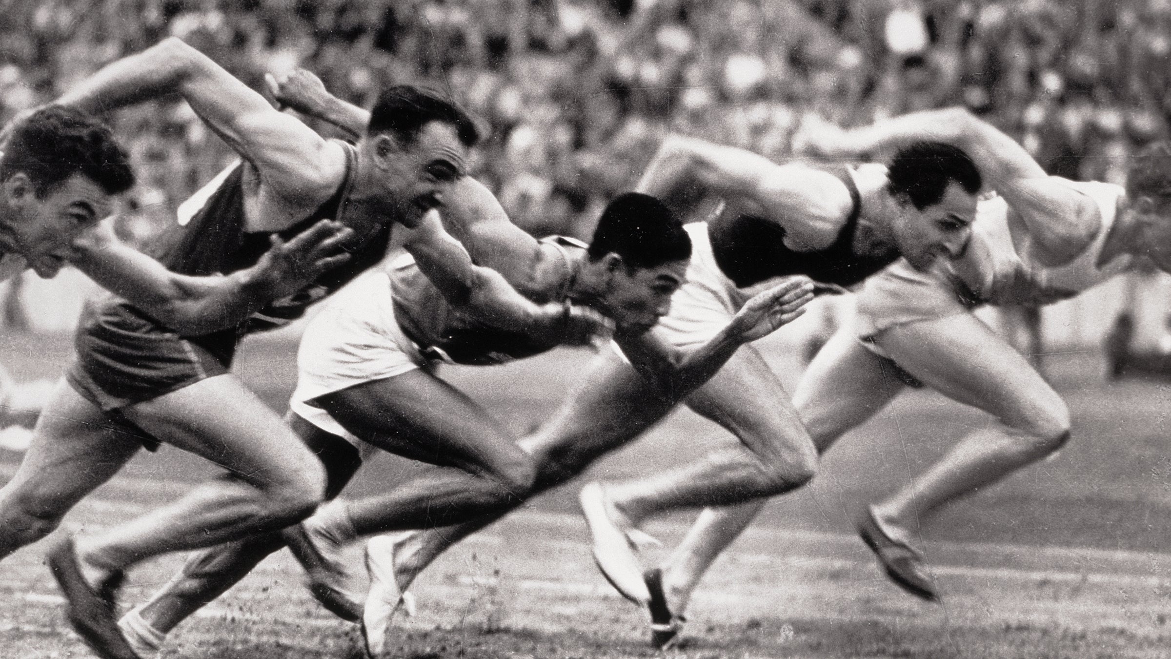 Archival photo of sprinters at the start line of a race