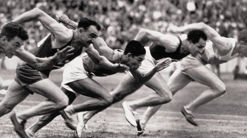 Archival photo of sprinters at the start line of a race