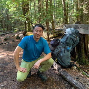 Troy Sicotte of Mountain Hardwear kneeling on the trail in a blue shirt