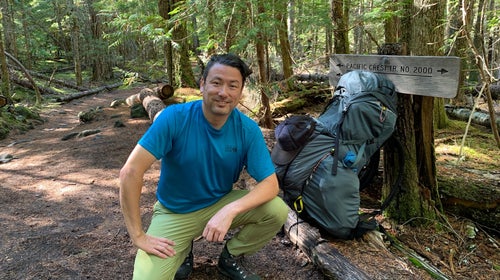Troy Sicotte of Mountain Hardwear kneeling on the trail in a blue shirt