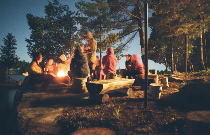 People gathered around a campfire in the woods