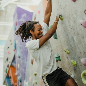 A man climbing in a New York City climbing gym.