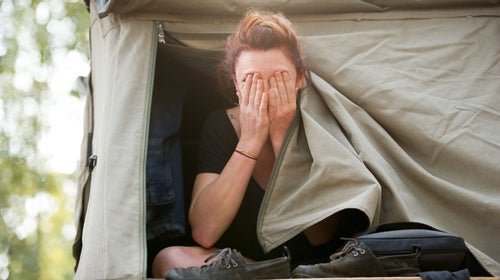 A woman waking up in a tent after insomnia camping