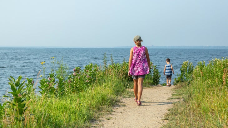 Rear view of a girl walking down a gravel path on the shore of Lake Bemidji in Minnesota, USA