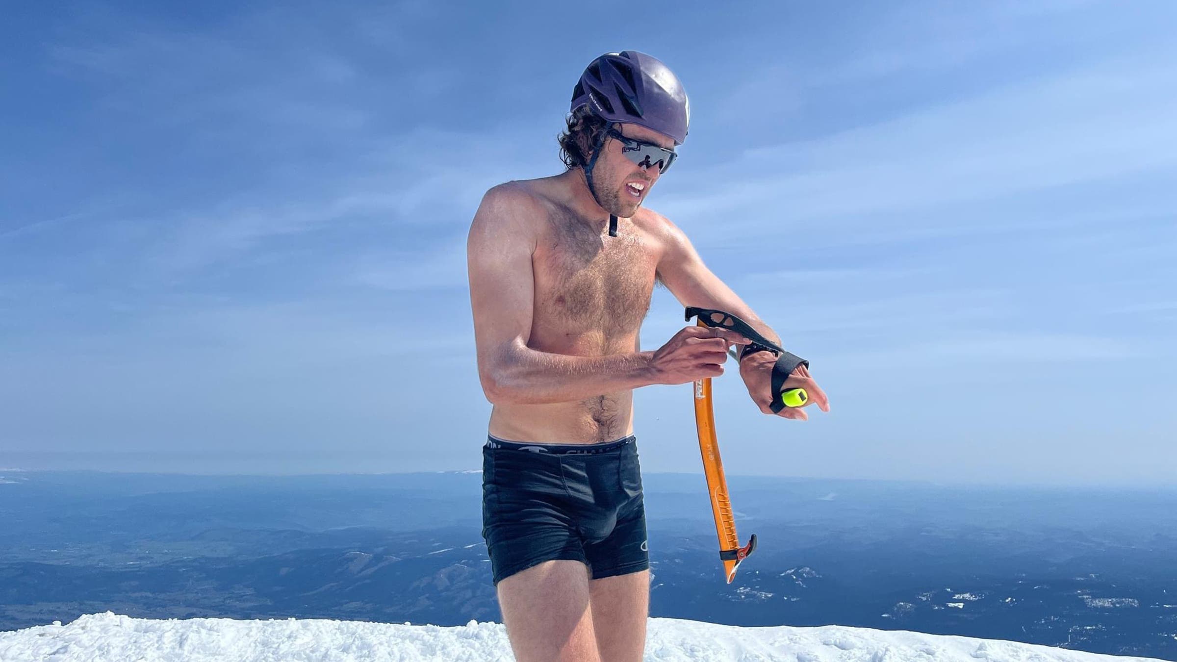 Jack Kuenzle atop a mountain in front of a landscape
