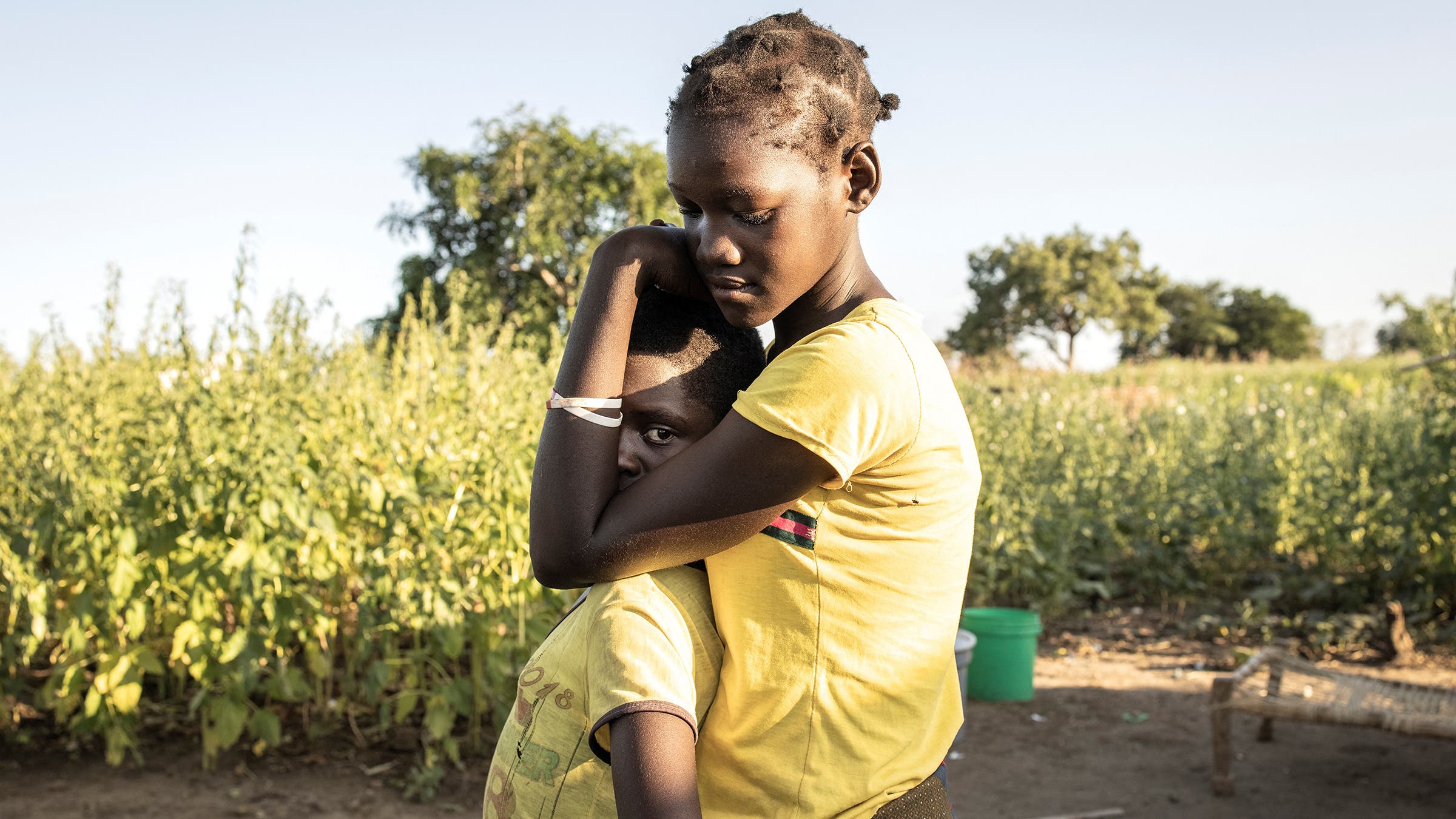 Two young girls embrace at a resettlement camp after fleeing the violence in northern Mozambique.