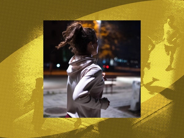 A woman runs at night with headphones