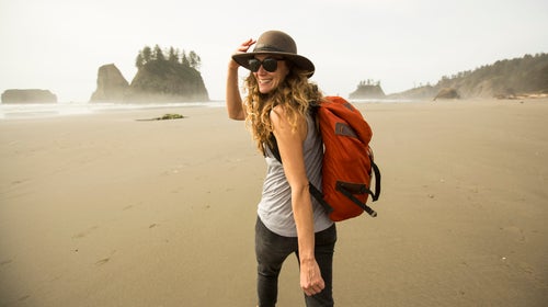 A woman hiking alone on the beach.