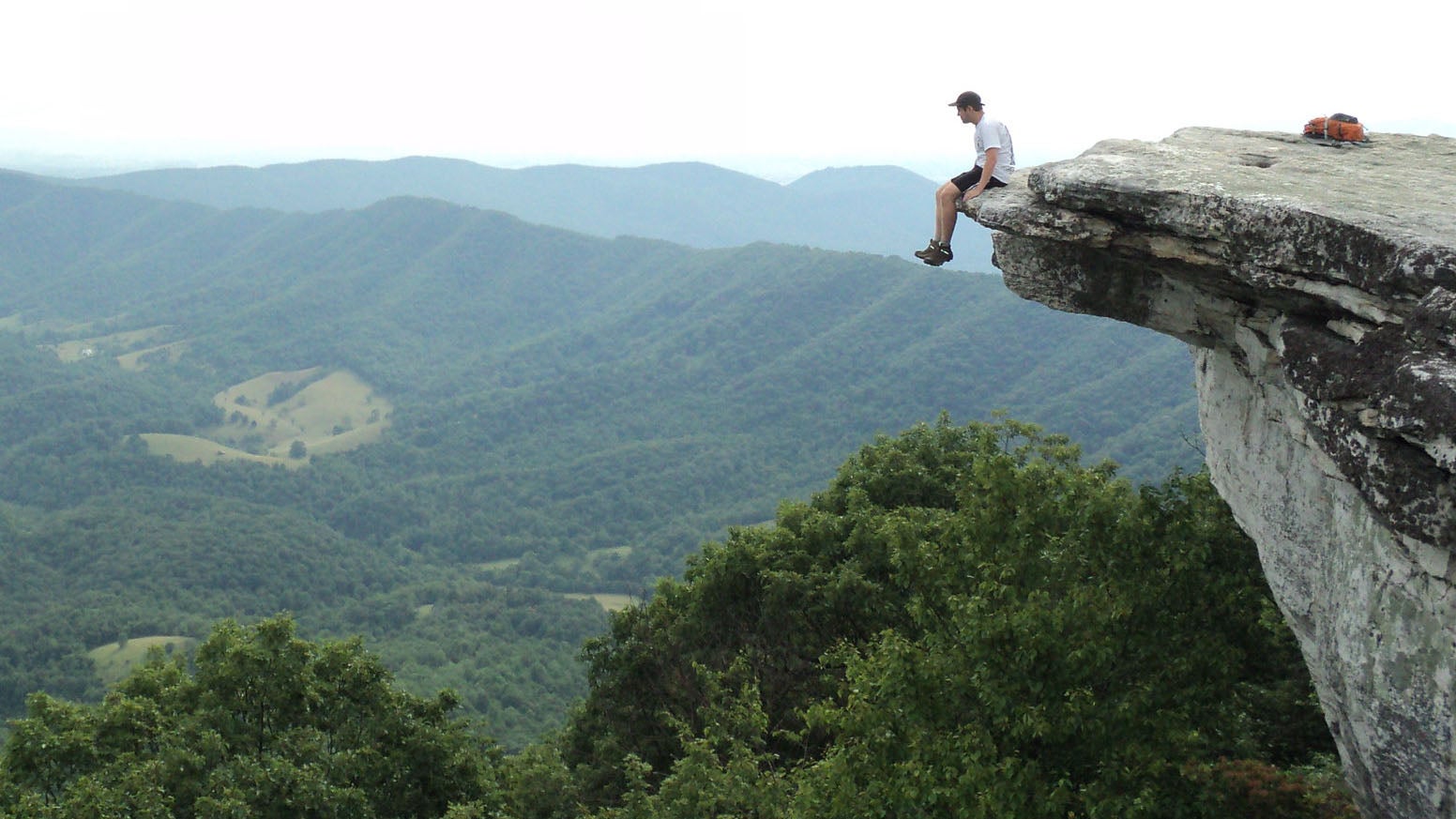 A hiker sits on McAfee Knob.