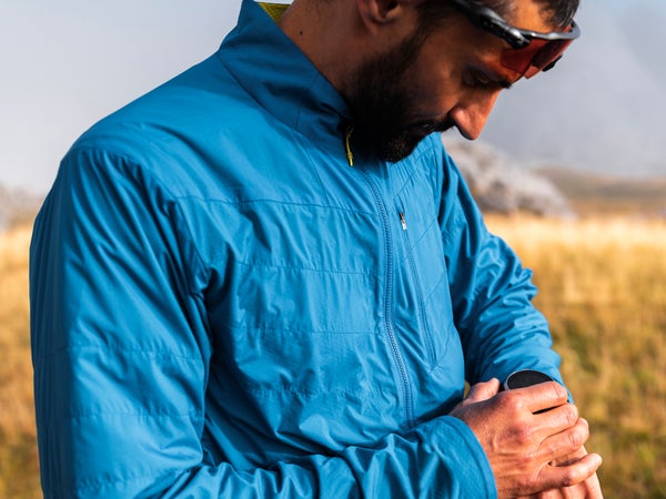 Trail runner using training watch on a foggy day