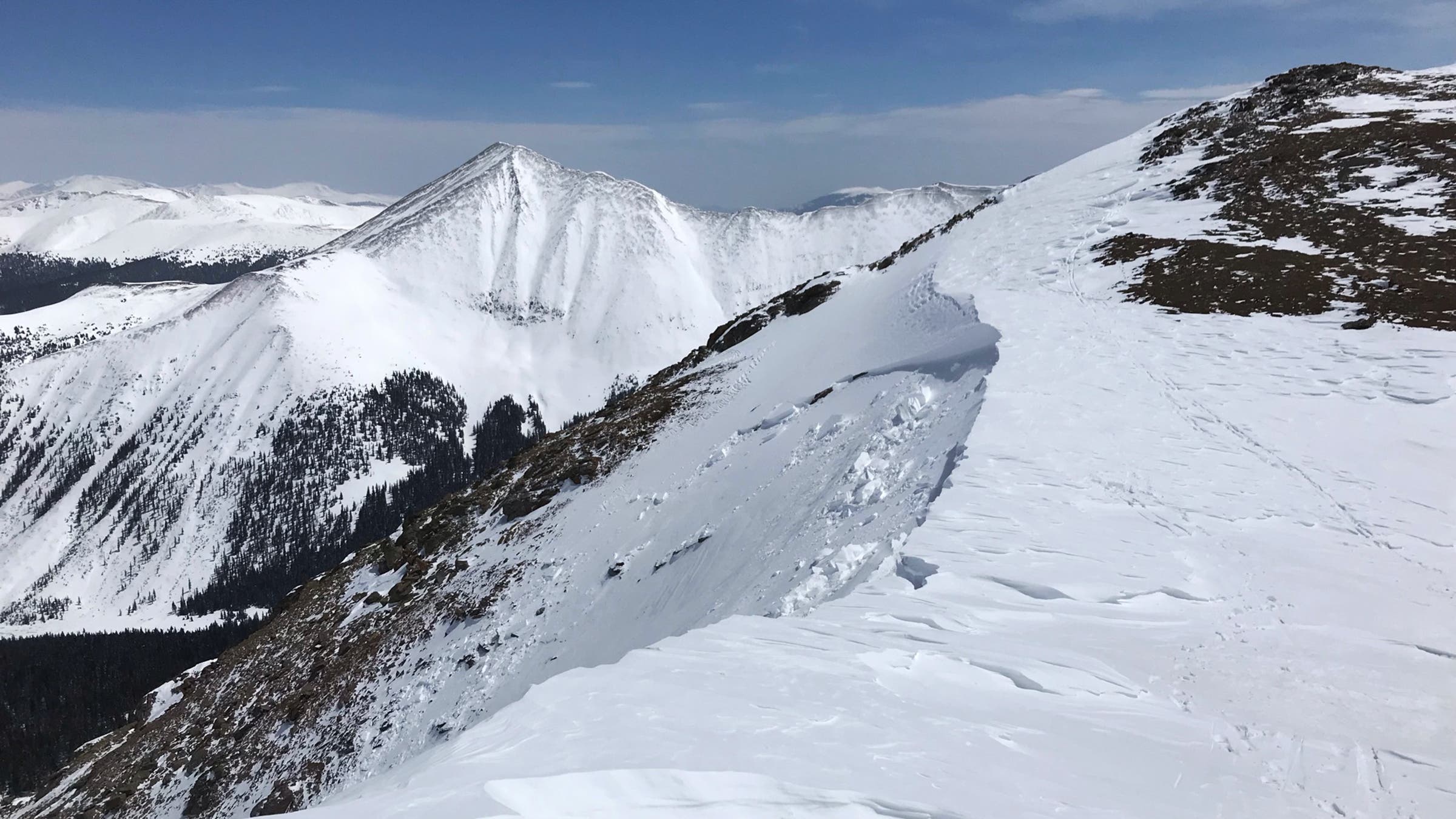 The first wind slab ripped out from the cornice at 13,000 feet, sending thick chunks sliding downhill.