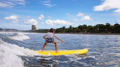 Young girl athlete learning to surf